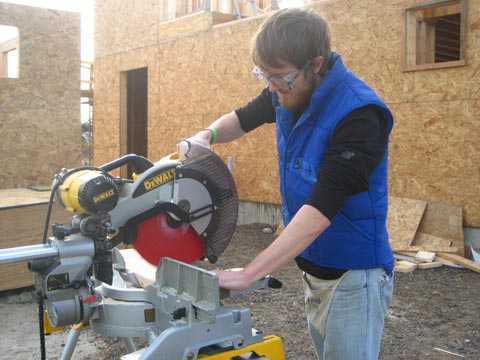 Brett (intern) cutting wood pieces for roof truss 