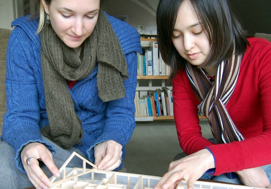 Two interns building an architectural model